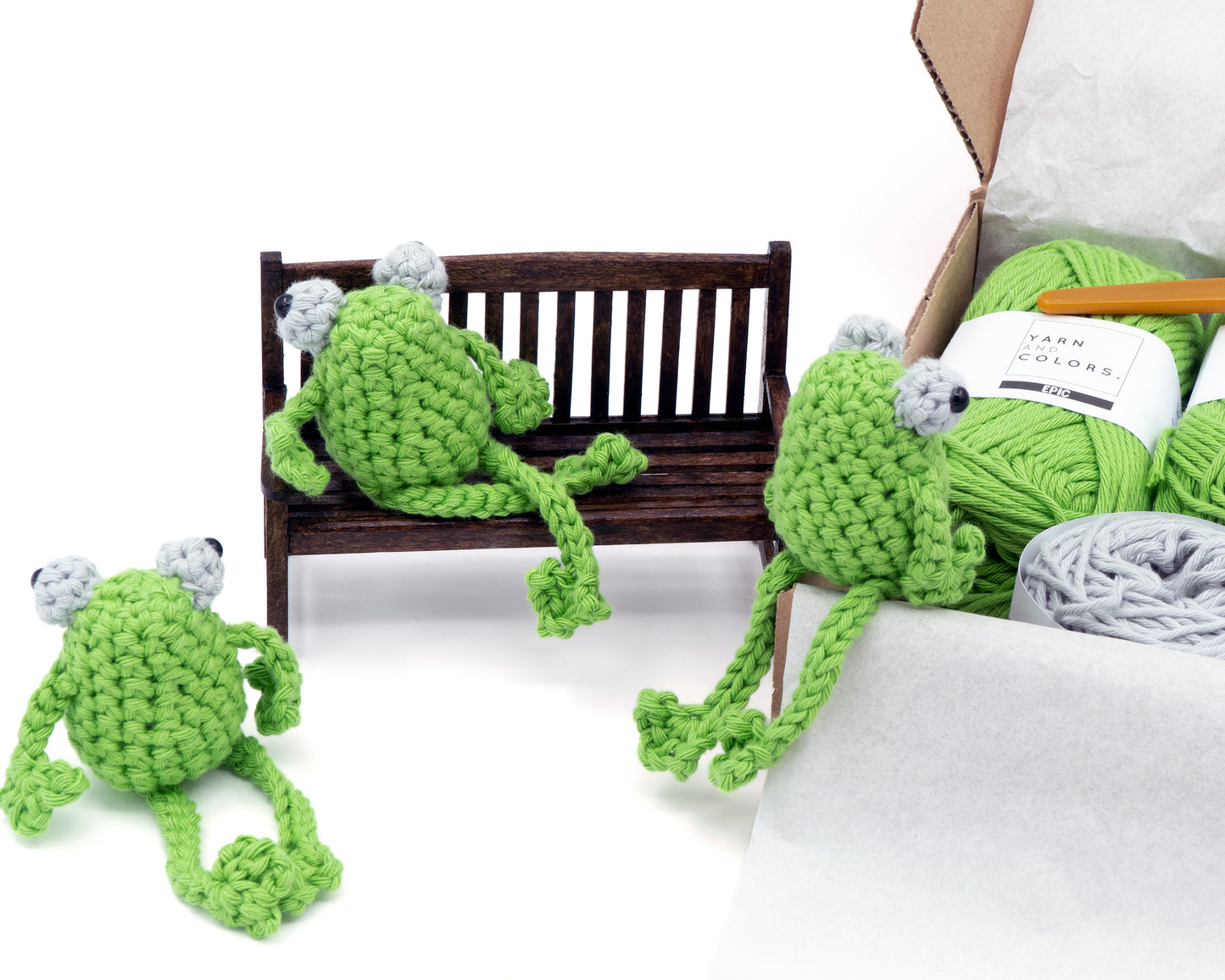 amigurumi crochet sitting frog kit three little frogs sitting next to a box of yarn