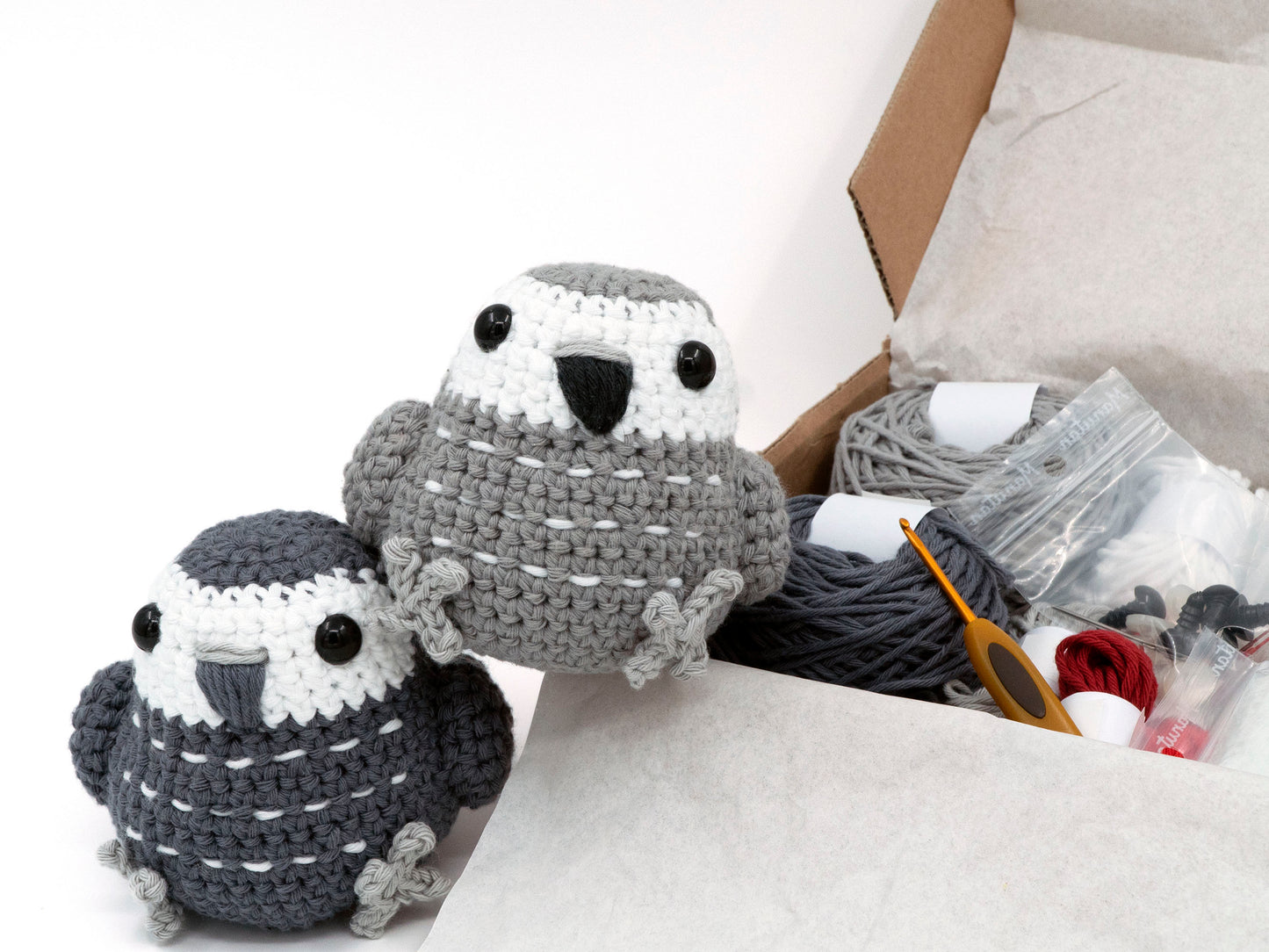 amigurumi crochet african grey kit two parakeets sitting next to a box of yarn