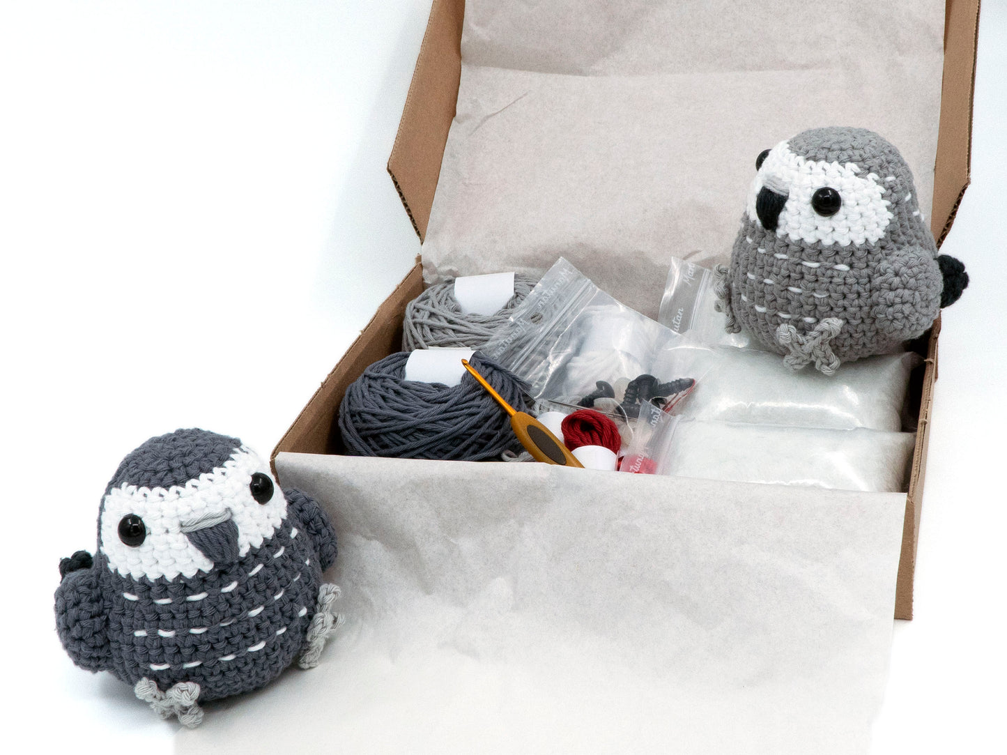 amigurumi crochet african grey kit congo grey and timneh grey sitting inside a box full of yarn