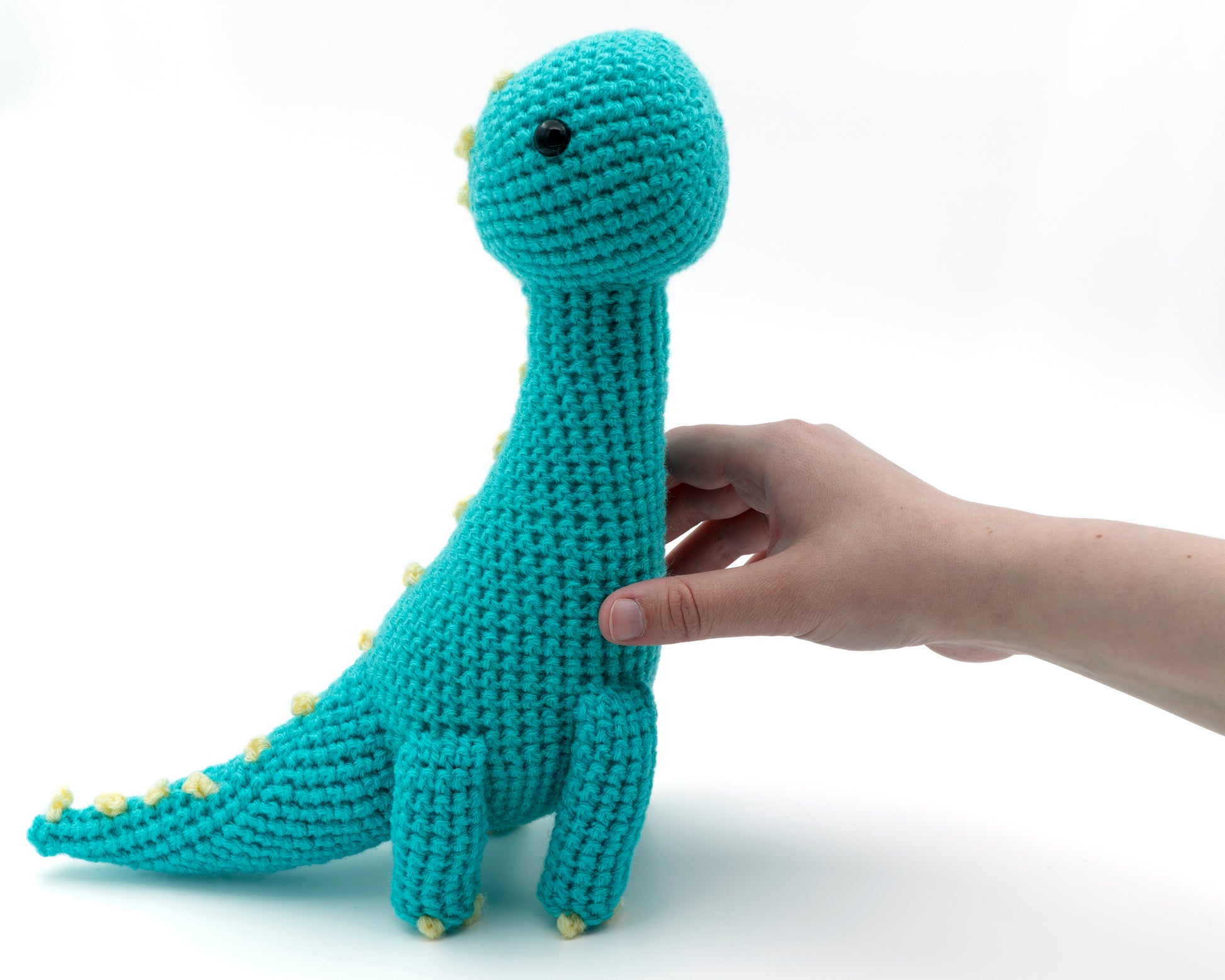 amigurumi crochet brachiosaurus dinosaur pattern in hand for size comparison