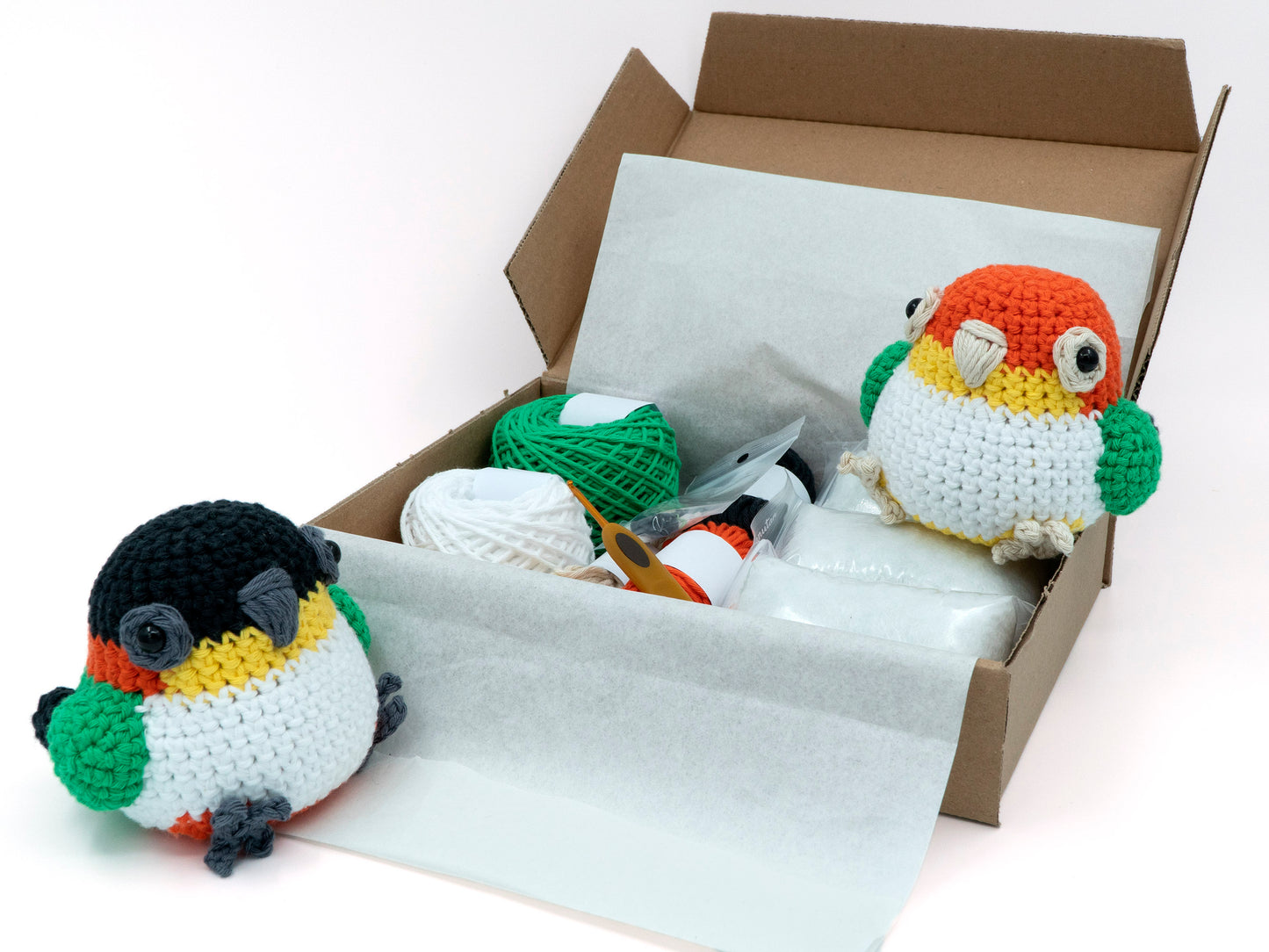 amigurumi crochet caique kit two parrots sitting inside a box of yarn