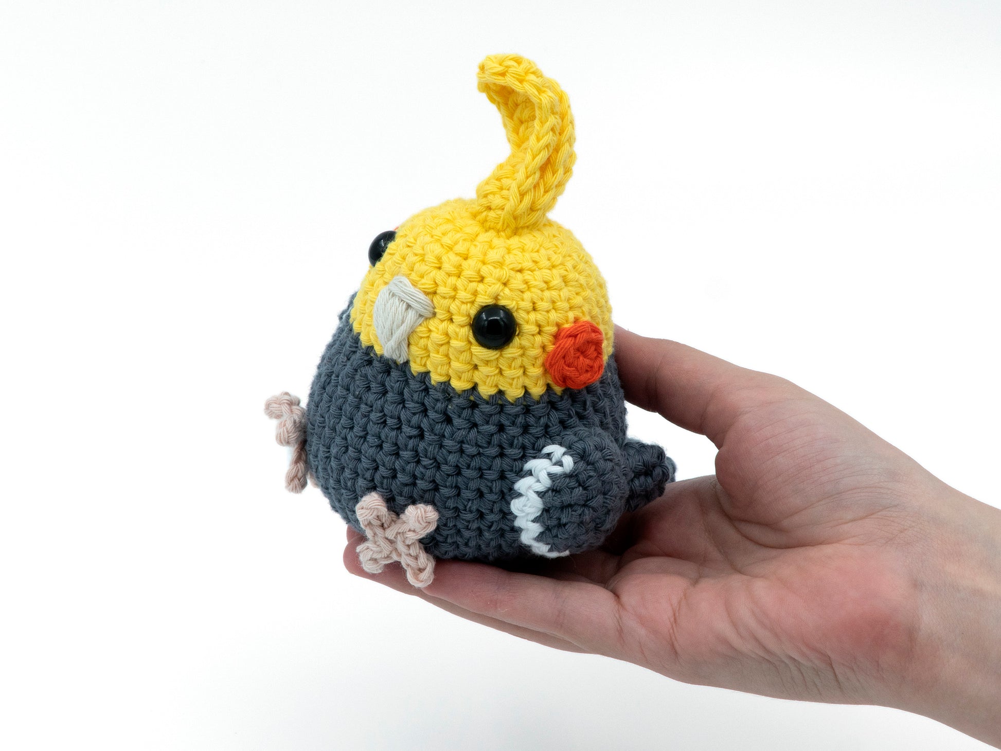 amigurumi crochet cockatiel pattern grey in hand for size comparison