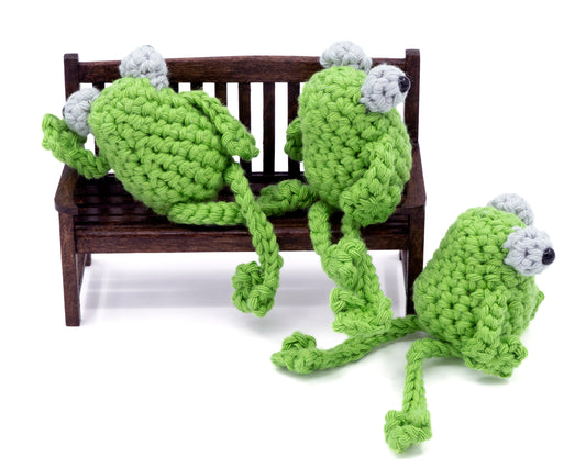 amigurumi crochet sitting frog pattern sitting in on a tiny bench 