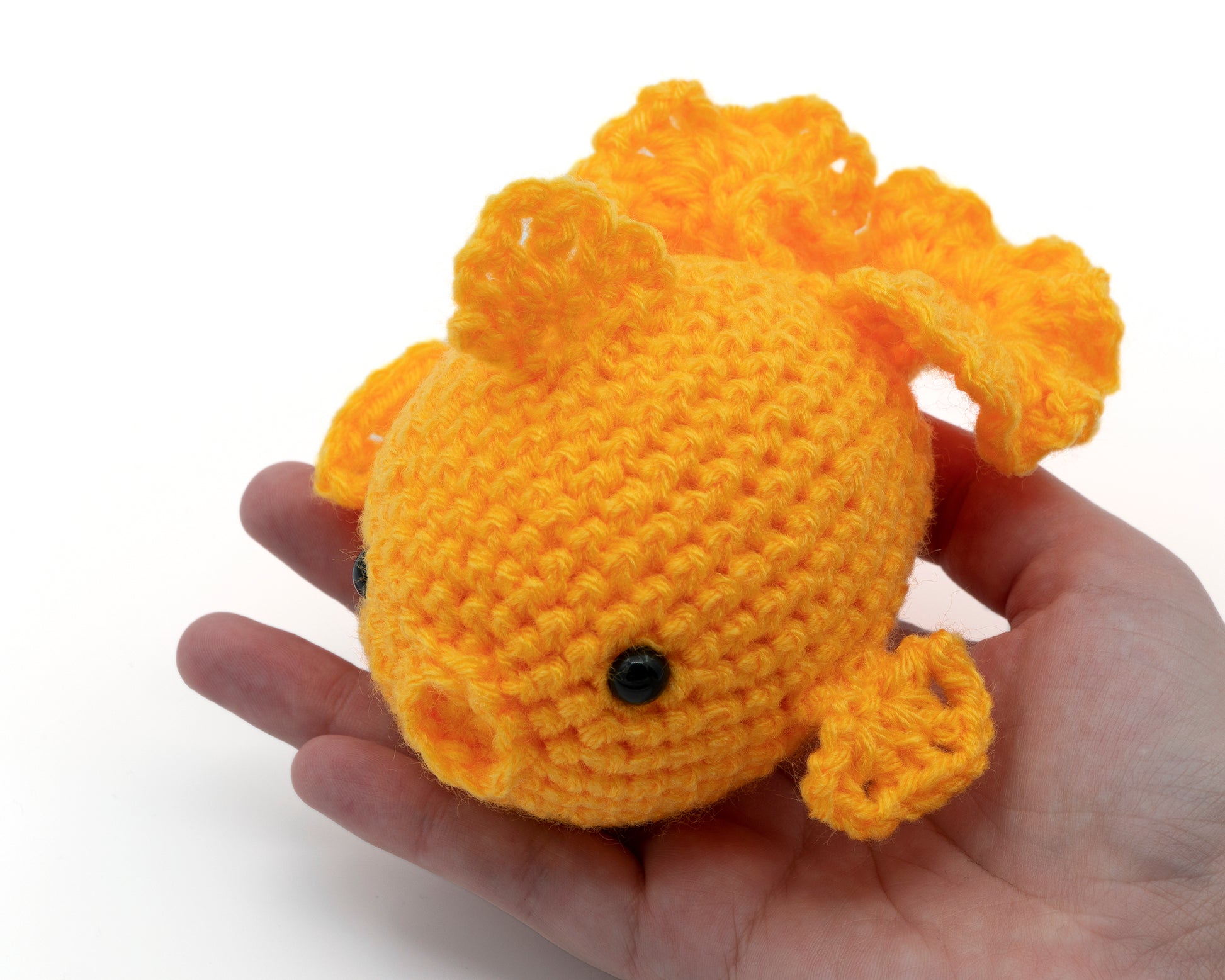 amigurumi crochet goldfish pattern in hand for size comparison
