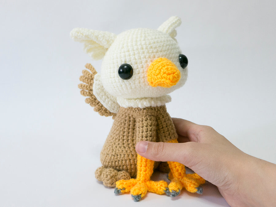 amigurumi crochet griffin pattern in hand for size comparison