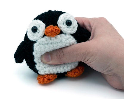 amigurumi crochet penguin pattern squished in hand for size comparison