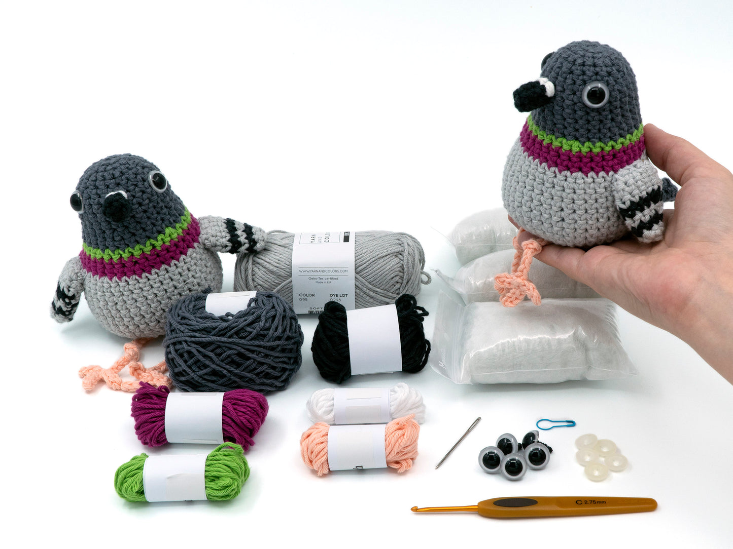 amigurumi crochet pigeon kit a bird being held above the contents of the crochet kit