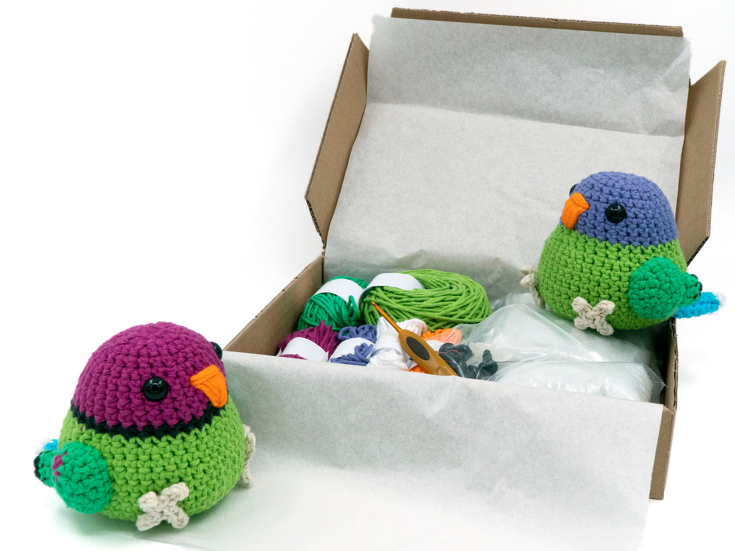 amigurumi crochet plum-headed parakeet kit two parrots sitting inside a box of yarn