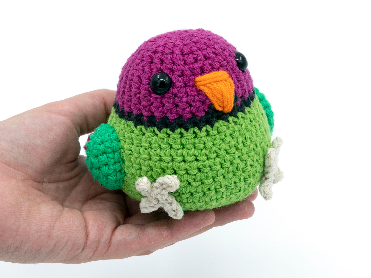 amigurumi crochet plum-headed parakeet male in hand for size comparison