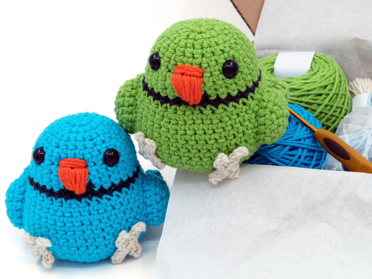 amigurumi crochet indian ringneck kit two birds sitting next to a box of yarn