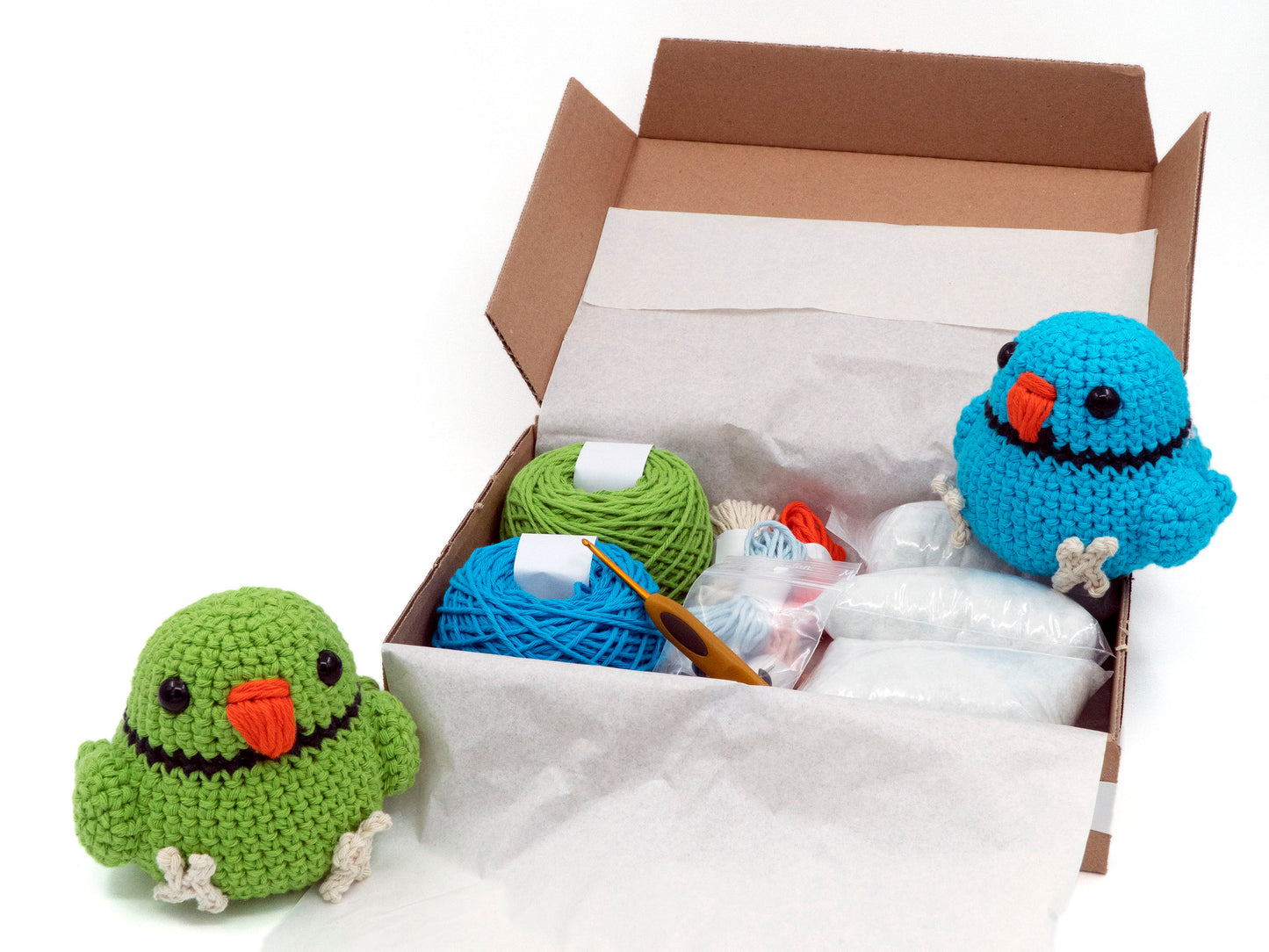 amigurumi crochet indian ringneck kit two birds sitting inside a box of yarn