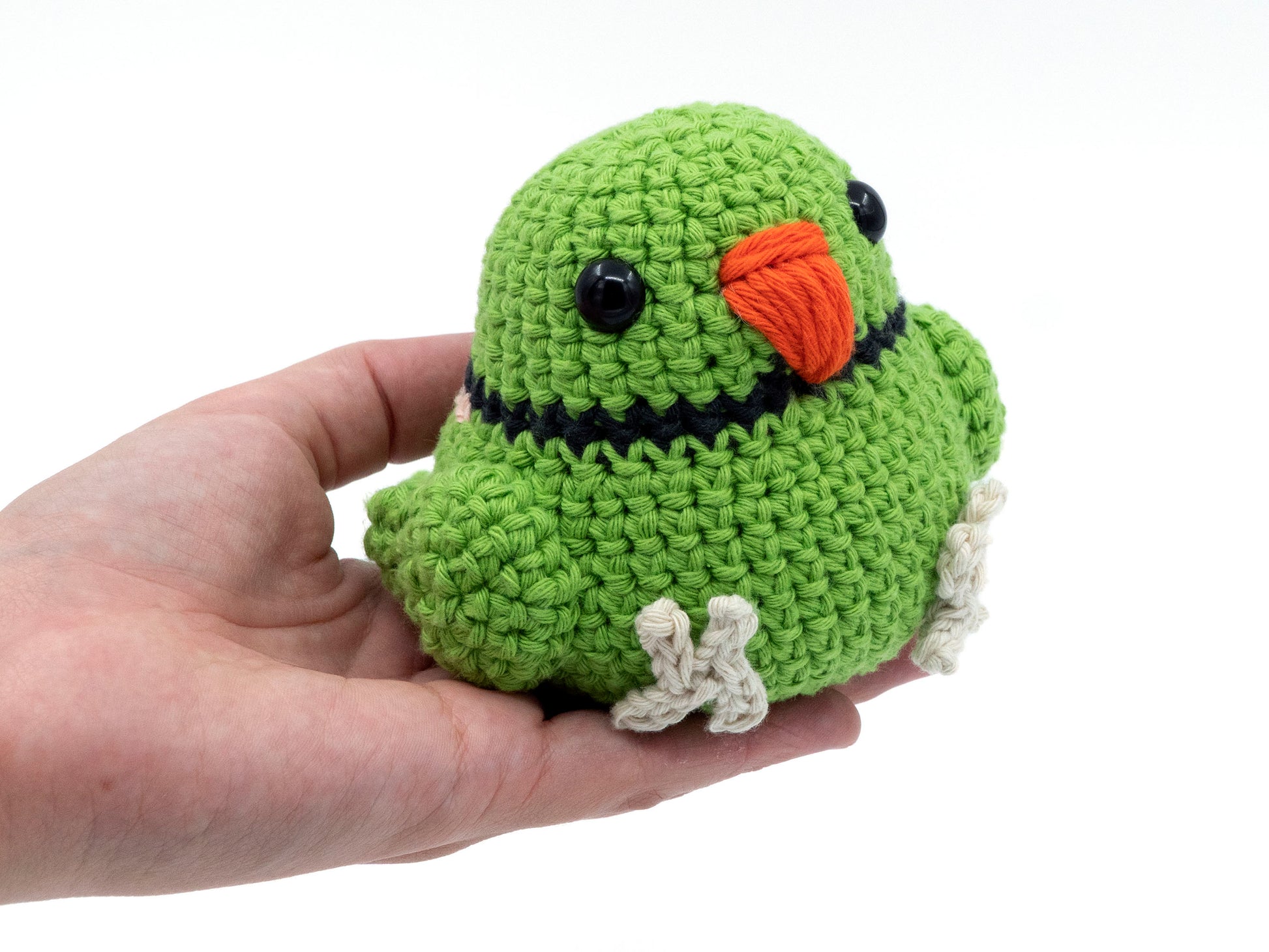 amigurumi crochet indian ringneck pattern green in hand for size comparison