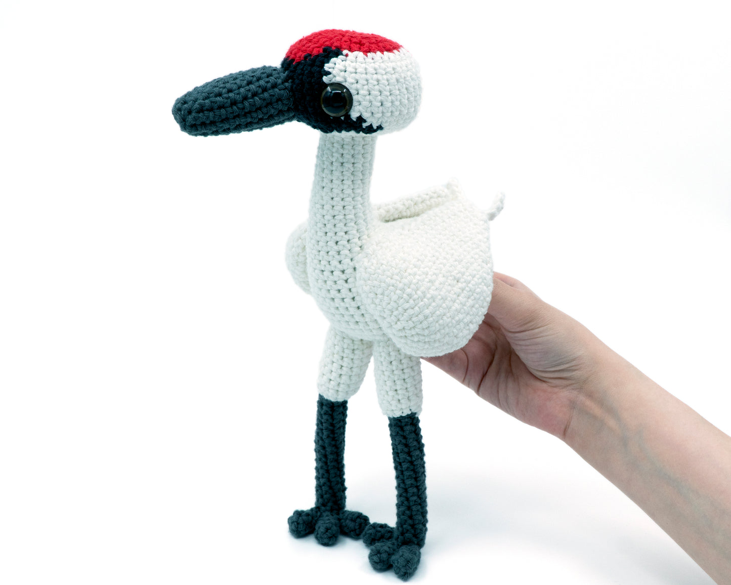 amigurumi crochet whooping crane pattern in hand for size comparison