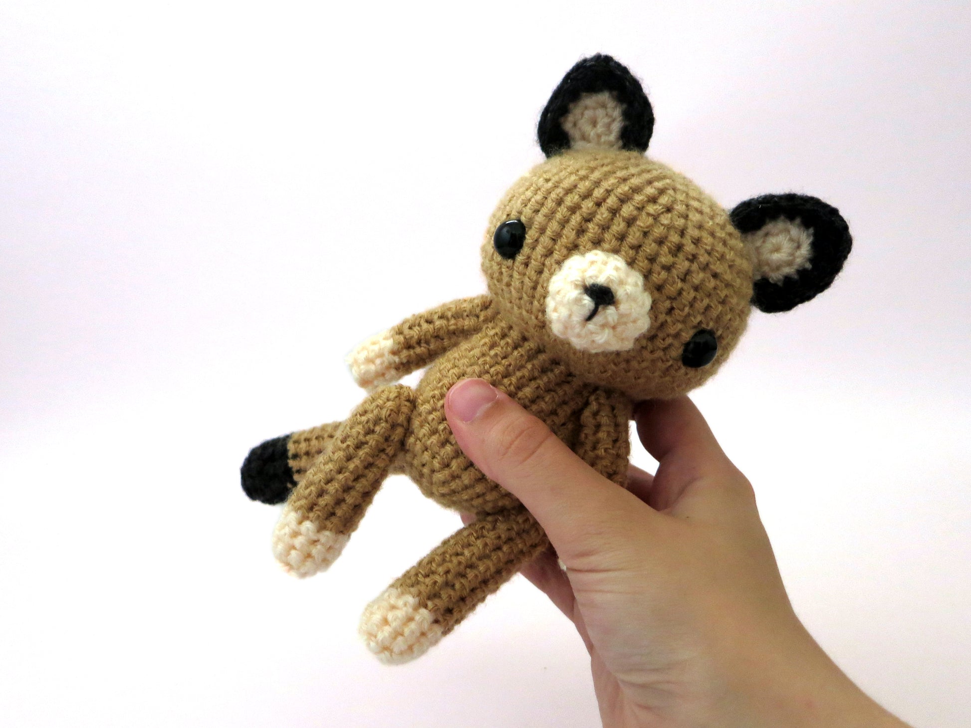 amigurumi crochet cougar pattern in hand for size comparison