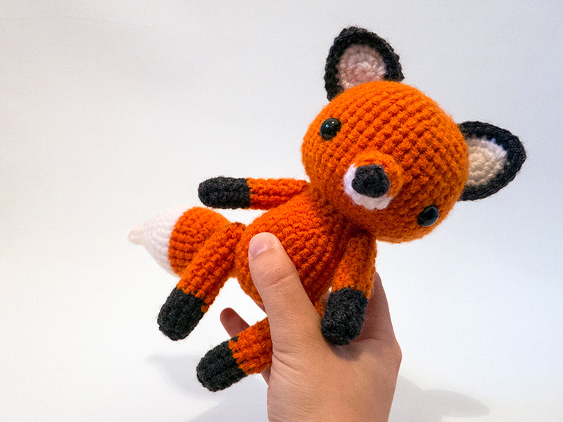 amigurumi crochet fox pattern in hand for size comparison