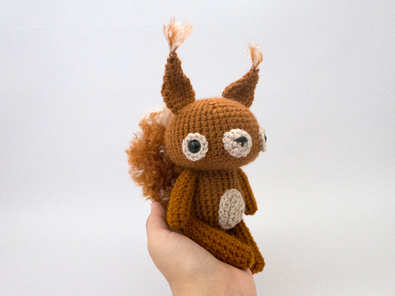 amigurumi crochet squirrel pattern in hand for size comparison