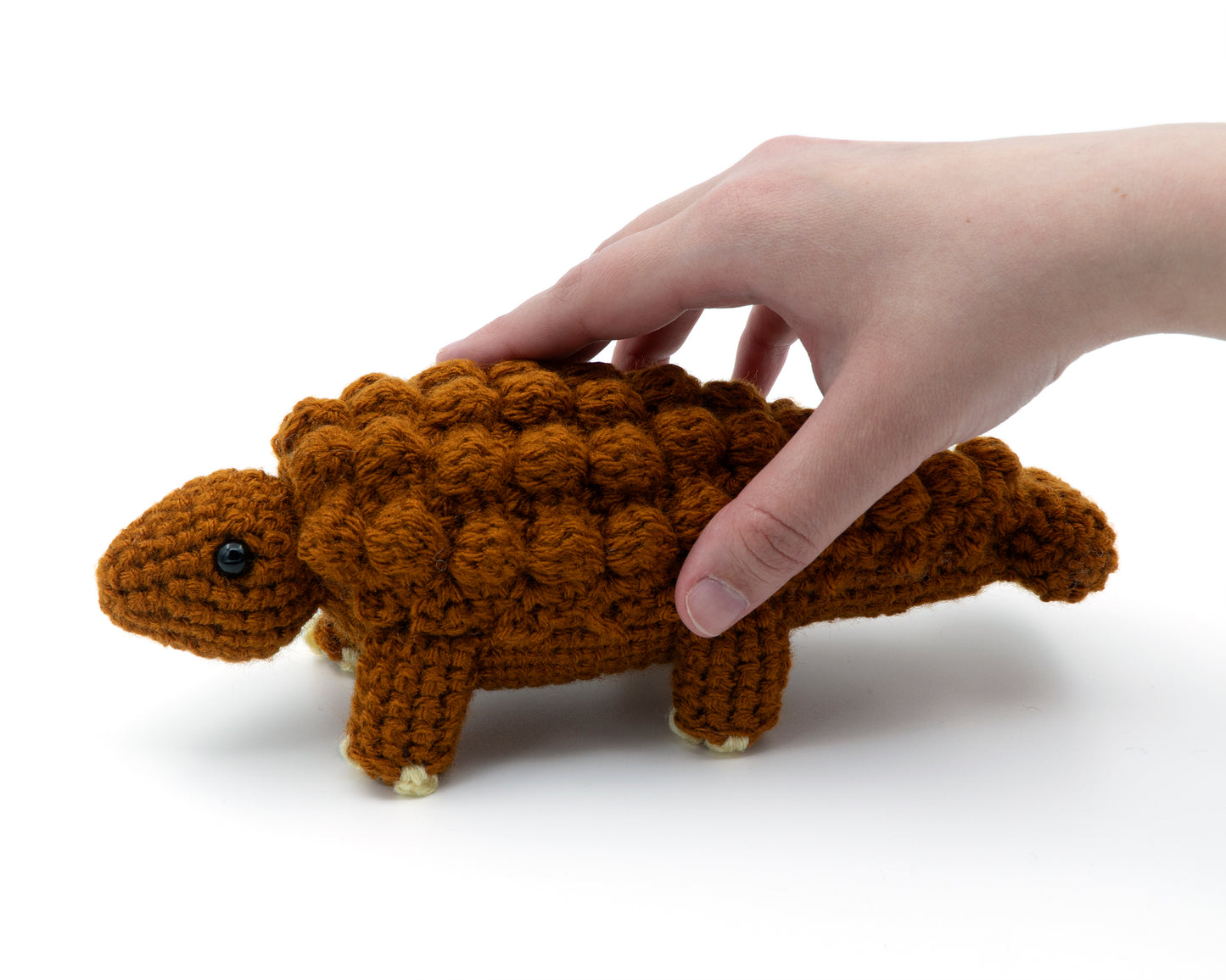 amigurumi crochet ankylosaurus pattern in hand for size comparison