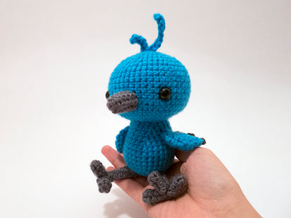amigurumi crochet bluebird pattern in the hand for size comparison
