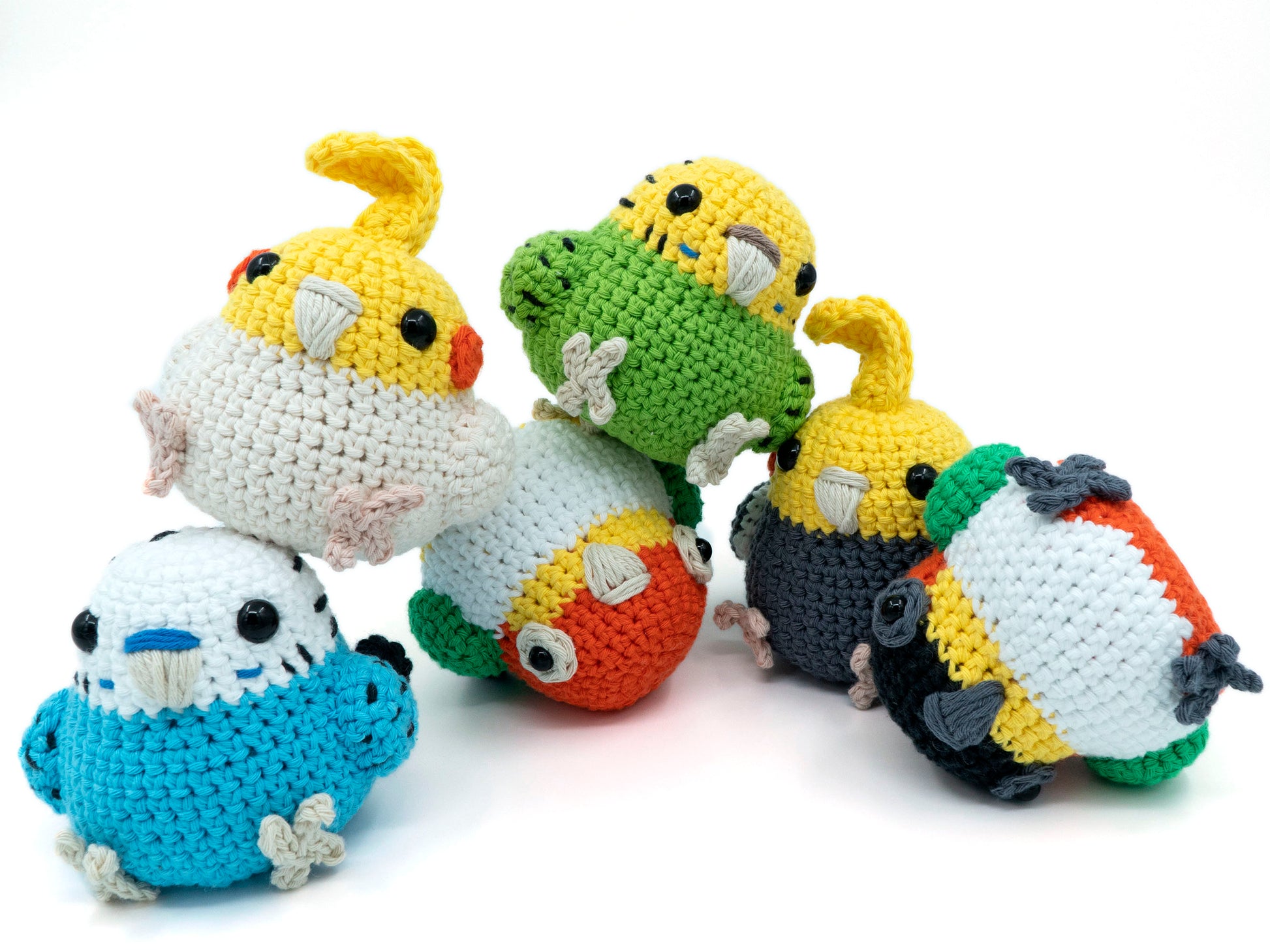amigurumi crochet parrot pattern bundle with cockatiel budgie and caique stacked in a pile