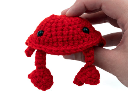 amigurumi crochet crab pattern in hand for size comparison