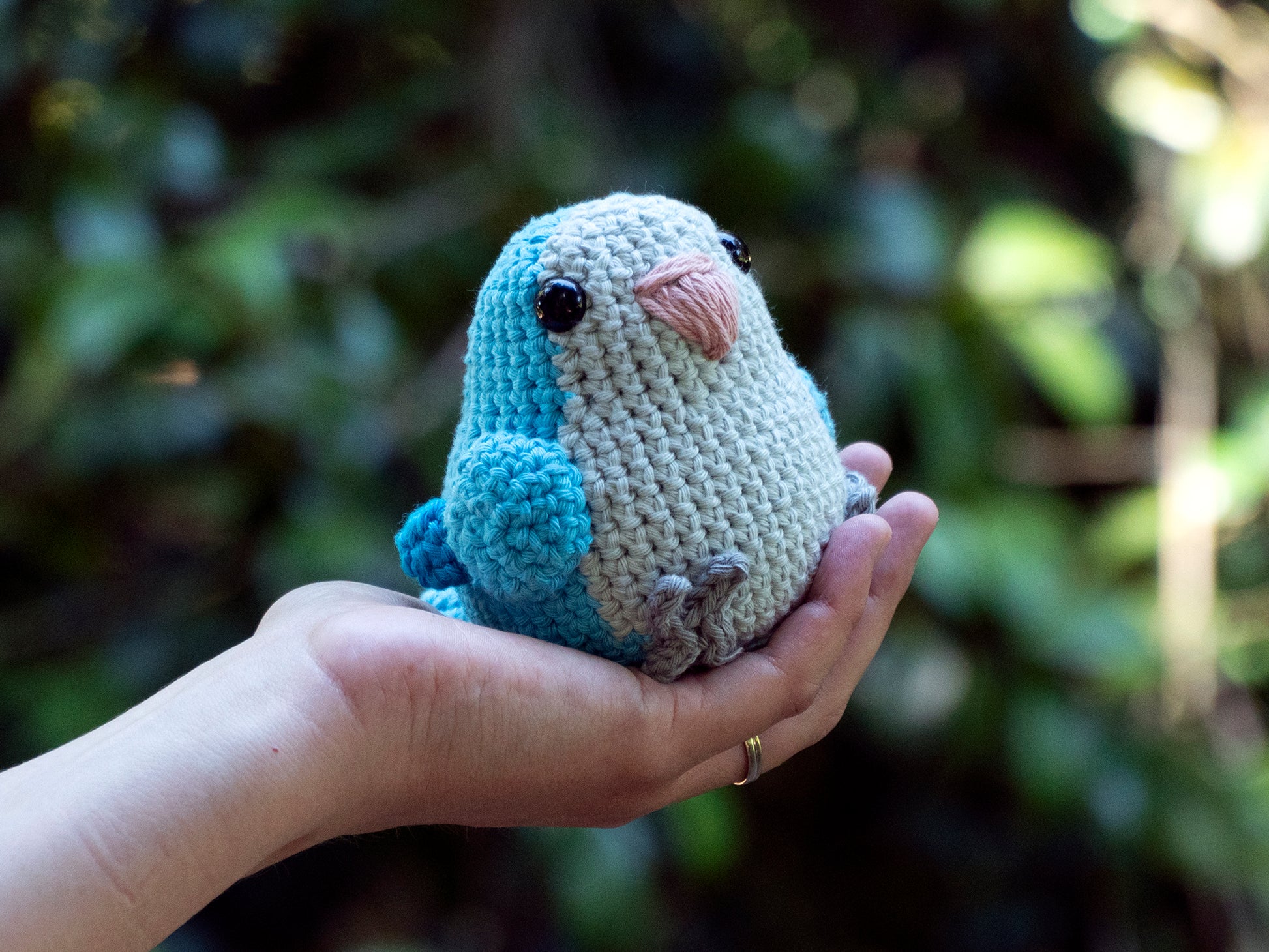 handmade crochet quaker parrot monk parakeet amigurumi plush blue being picked up for size comparison