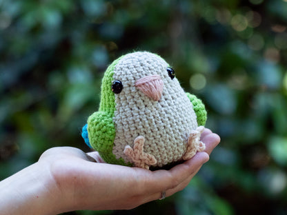 handmade crochet quaker parrot monk parakeet amigurumi plush green sitting on a hand for size comparison