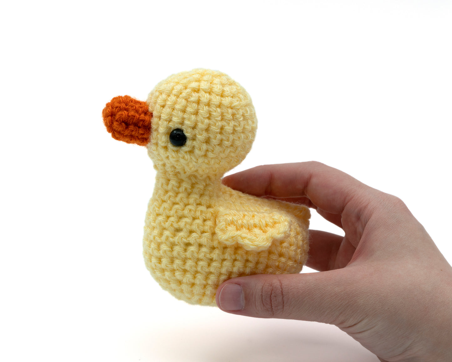 amigurumi crochet duckling pattern in hand for size comparison