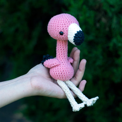 handmade crochet flamingo amigurumi plush pink bird sitting pose in a hand for size comparison