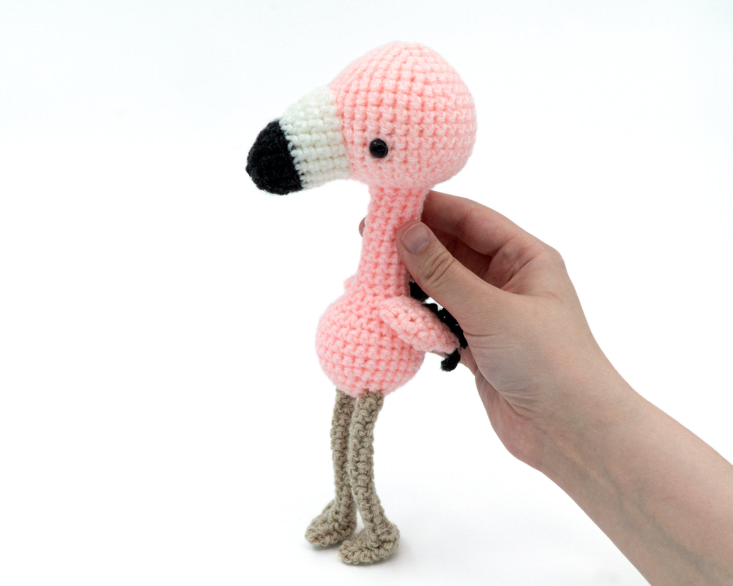 amigurumi crochet flamingo pattern in hand for size comparison