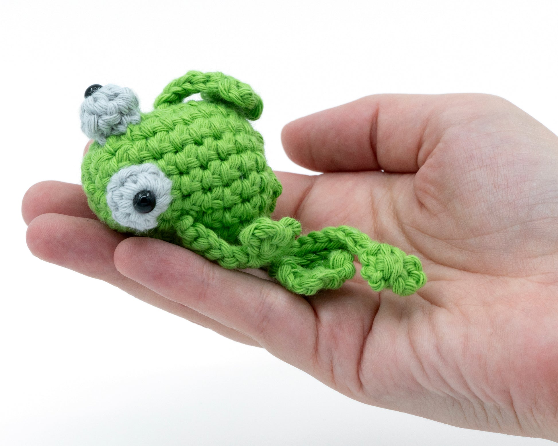 amigurumi crochet sitting frog pattern laying in a hand