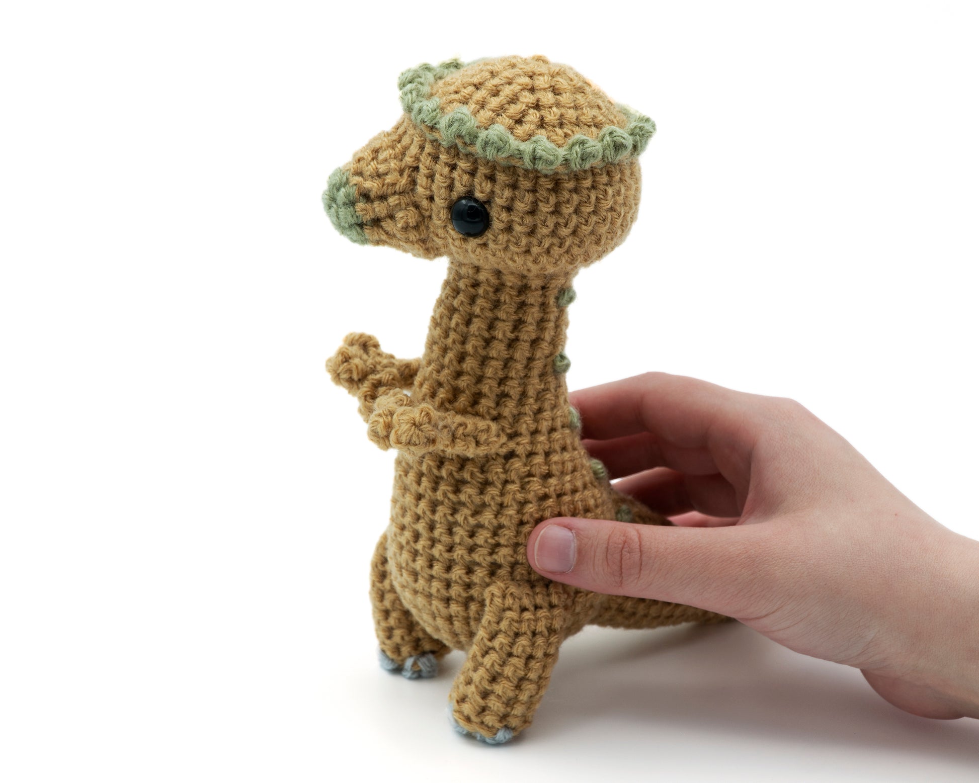 amigurumi crochet pachycephalosaurus pattern in hand for size comparison