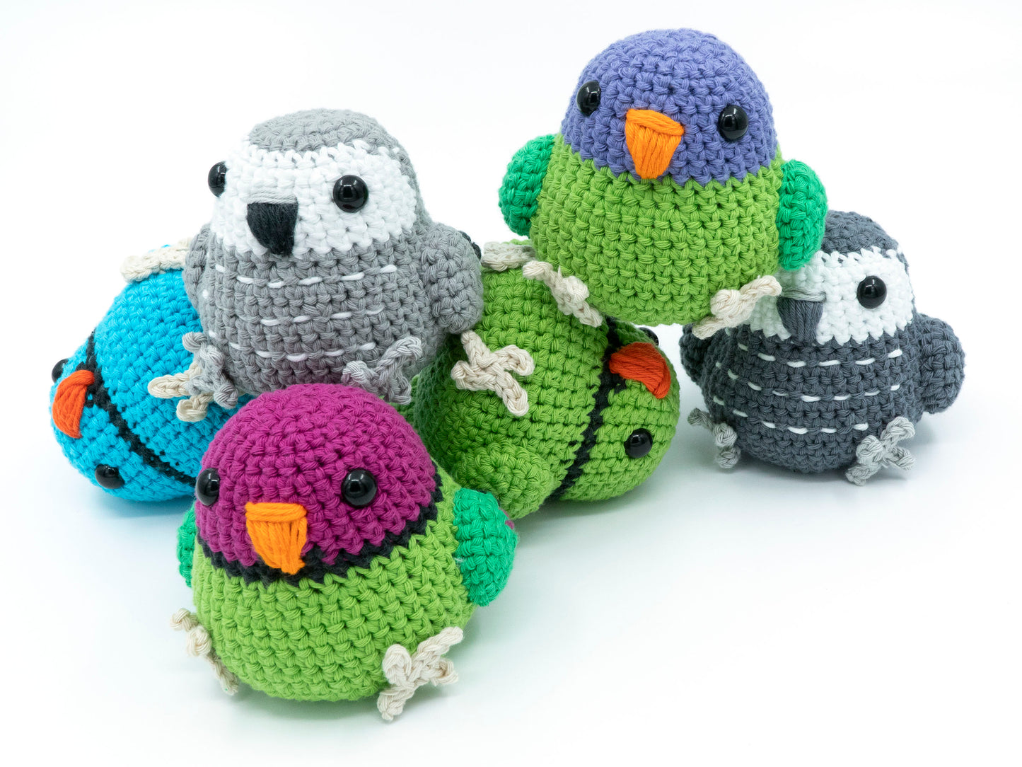 amigurumi crochet parrot pattern bundle with african grey plum-headed parakeet and indian ringneck stacked in a pile
