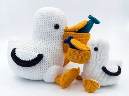 two crochet pelicans with fish in their mouths