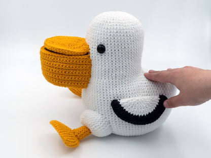 a large amigurumi pelican being petted