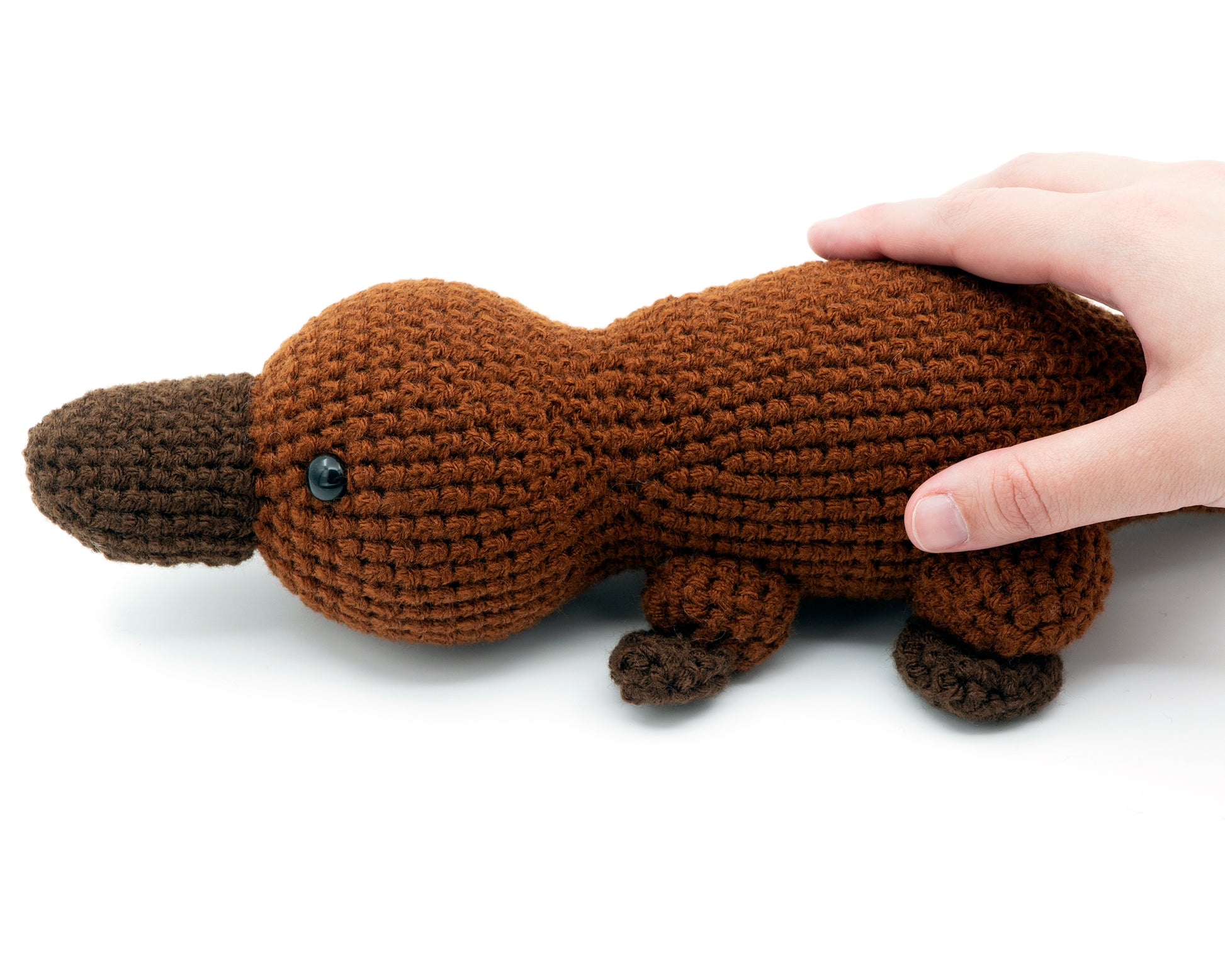 amigurumi crochet platypus pattern in hand for size comparison