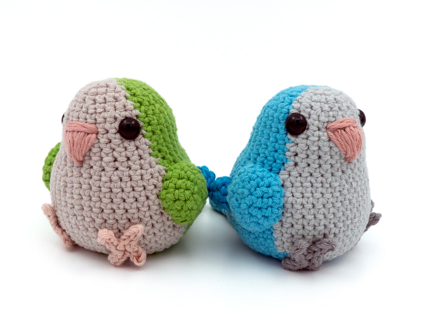 handmade crochet quaker parrot monk parakeet amigurumi plush green and blue sitting together facing away from one another