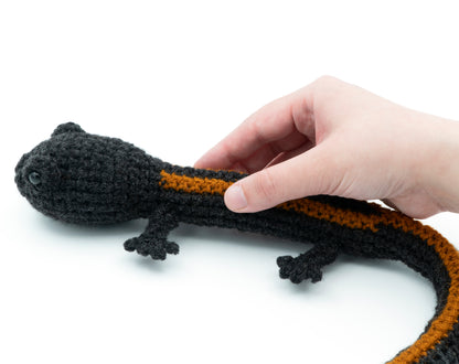 amigurumi crochet salamander pattern in hand for size comparison