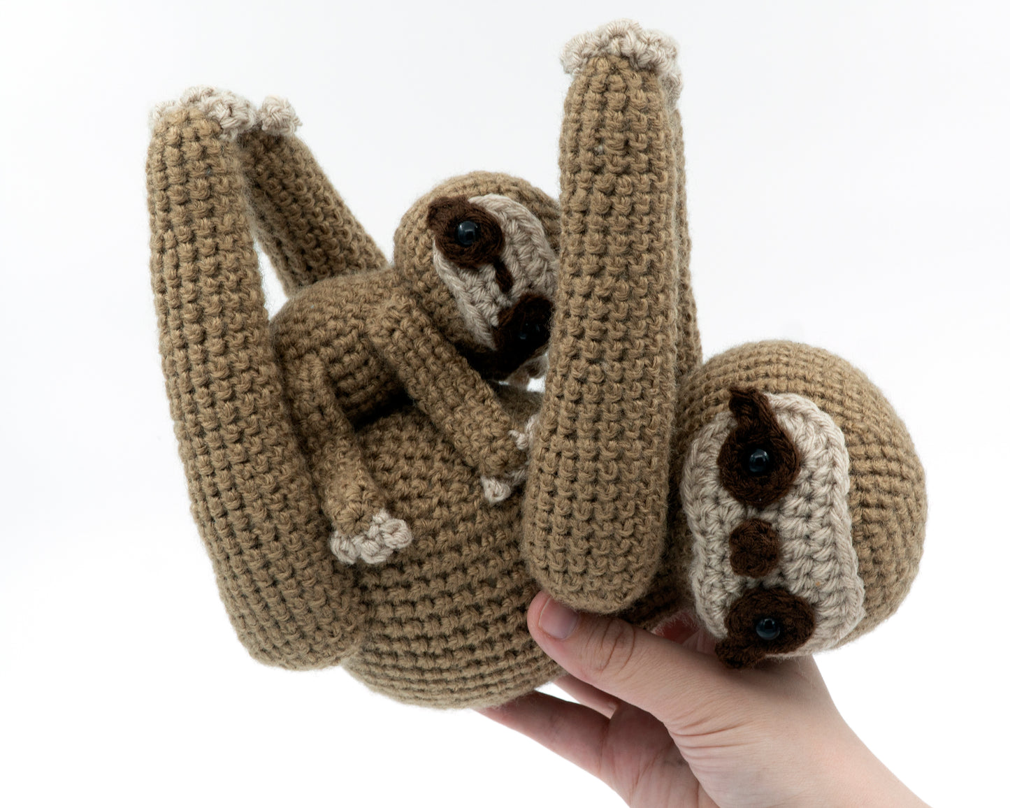 amigurumi crochet sloth pattern in hand for size comparison