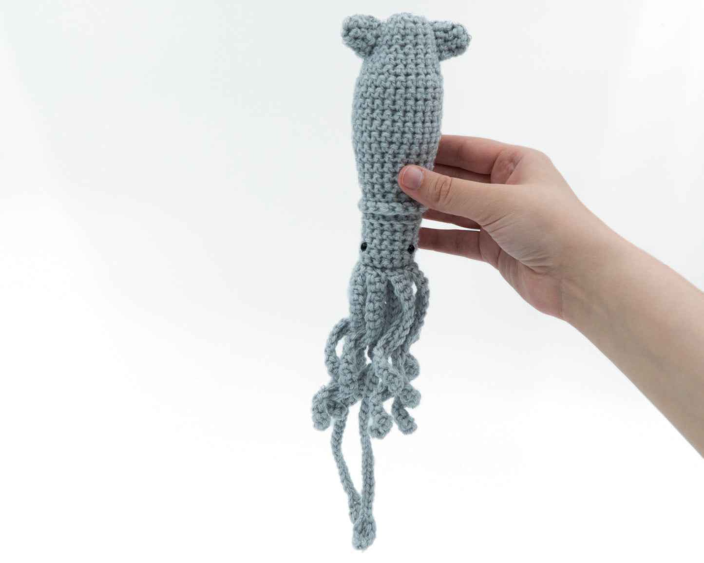 amigurumi crochet squid pattern in hand for size comparison