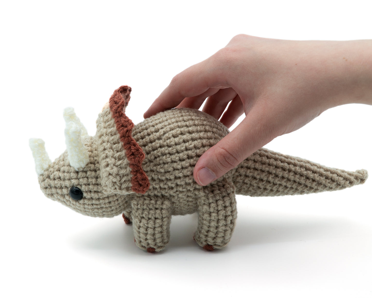 amigurumi crochet triceratops pattern in hand for size comparison